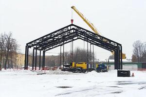 A large metal structure being built in the snow photo