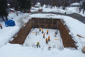 A group of workers are working on a large hole in the snow photo