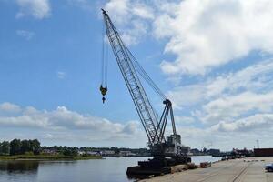 A crane is lifting a boat on a dock photo