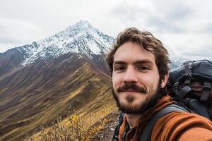 A man with a backpack and a beard taking a selfie photo