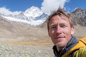 A man taking a selfie in front of a mountain photo