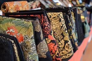 A row of purses lined up on a table photo