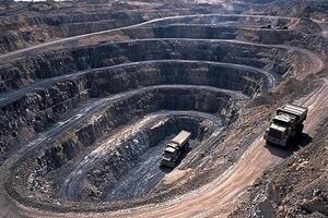 A large open pit with trucks driving through it photo