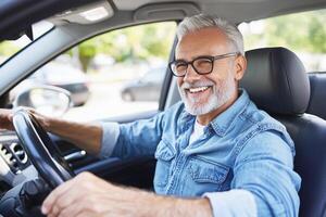 A man with glasses and a beard driving a car photo