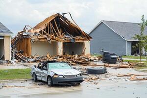 A car is parked in front of a house that has been destroyed photo