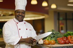 A chef holding a knife in front of a table with vegetables photo
