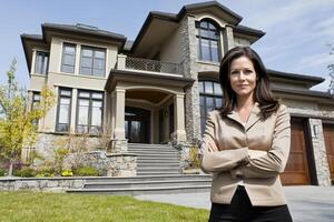 A woman standing in front of a large house photo