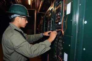 A man in a hard hat working on a computer photo