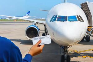 A person holding a boarding pass in front of an airplane photo