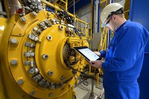 A man in a blue uniform is using a tablet photo