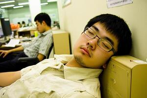 A man sleeping on a desk photo