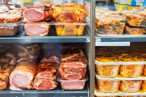 A display case filled with meat and other food photo