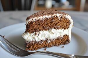 A piece of cake on a plate with a fork photo