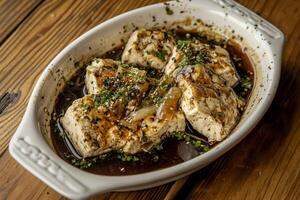 A white dish with tofu and sauce on top photo