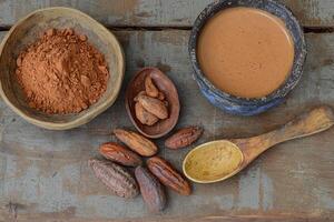 Cocoa powder, cocoa beans, and cocoa beans on a wooden table photo