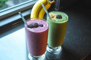 Two smoothies sit on a counter next to a banana photo