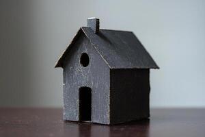 A small black birdhouse sits on a table photo