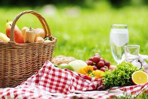 A picnic basket with fruits and vegetables on the grass photo