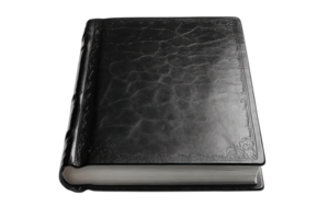 Black leather-bound book resting on a flat surface, showcasing a classic and elegant design png