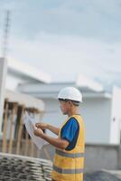 Engineering Consulting People on construction site holding blueprint in his hand. Building inspector. Construction site check drawing and business workflow of new building photo