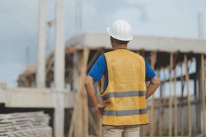 Asian man architect holds blueprint with skyscraper background, Asian male architect builder engineer design working planning confident outdoors in construction site. photo