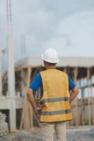 Asian man architect holds blueprint with skyscraper background, Asian male architect builder engineer design working planning confident outdoors in construction site. photo