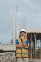 Asian man architect holds blueprint with skyscraper background, Asian male architect builder engineer design working planning confident outdoors in construction site. photo