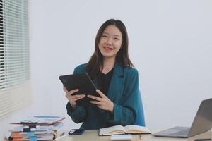 Asian professional businesswoman working on tablet computer in a corporate office photo