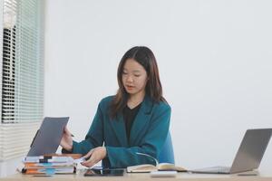 Asian professional businesswoman working on tablet computer in a corporate office photo