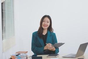 Asian professional businesswoman working on tablet computer in a corporate office photo