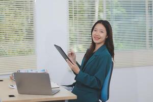 Asian professional businesswoman working on tablet computer in a corporate office photo