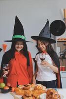 friendship, holiday and people concept - group of happy smiling friends in halloween costumes of vampire, devil, witch and cheetah at home party photo