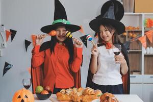 friendship, holiday and people concept - group of happy smiling friends in halloween costumes of vampire, devil, witch and cheetah at home party photo