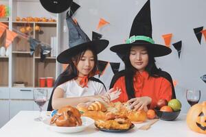 friendship, holiday and people concept - group of happy smiling friends in halloween costumes of vampire, devil, witch and cheetah at home party photo