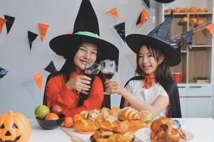 friendship, holiday and people concept - group of happy smiling friends in halloween costumes of vampire, devil, witch and cheetah at home party photo
