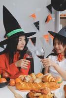 friendship, holiday and people concept - group of happy smiling friends in halloween costumes of vampire, devil, witch and cheetah at home party photo