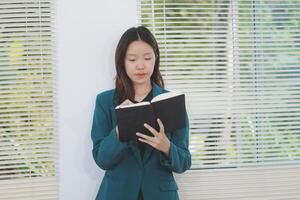 business woman working with laptop while consulting some invoice and document in working space at home photo