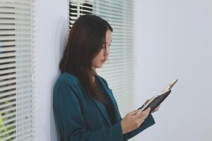 business woman working with laptop while consulting some invoice and document in working space at home photo