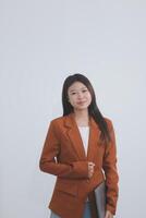 Attractive smiling Asian businesswoman standing holding tablet working and recording work details in office. photo