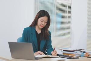 Asian professional businesswoman working on tablet computer in a corporate office photo