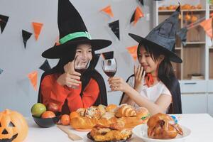 friendship, holiday and people concept - group of happy smiling friends in halloween costumes of vampire, devil, witch and cheetah at home party photo