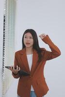 Happy relaxed young woman standing in home office using tablet, excited lady laughing holding tablet, enjoying doing online ecommerce shopping in mobile apps photo