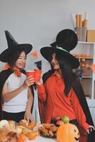 friendship, holiday and people concept - group of happy smiling friends in halloween costumes of vampire, devil, witch and cheetah at home party photo