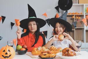 friendship, holiday and people concept - group of happy smiling friends in halloween costumes of vampire, devil, witch and cheetah at home party photo