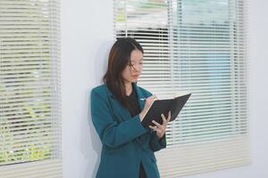 business woman working with laptop while consulting some invoice and document in working space at home photo