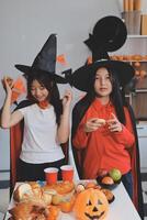 friendship, holiday and people concept - group of happy smiling friends in halloween costumes of vampire, devil, witch and cheetah at home party photo