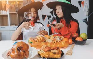 friendship, holiday and people concept - group of happy smiling friends in halloween costumes of vampire, devil, witch and cheetah at home party photo