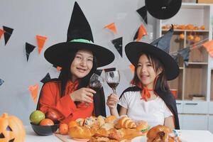 friendship, holiday and people concept - group of happy smiling friends in halloween costumes of vampire, devil, witch and cheetah at home party photo