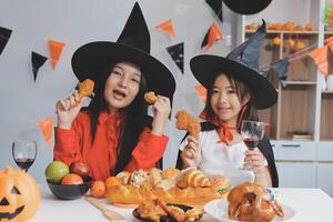 friendship, holiday and people concept - group of happy smiling friends in halloween costumes of vampire, devil, witch and cheetah at home party photo