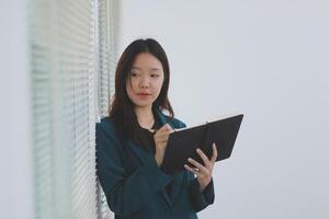 business woman working with laptop while consulting some invoice and document in working space at home photo